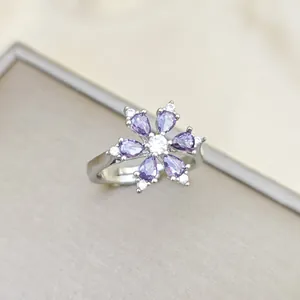 Close-up of adjustable flower ring with purple gems and white zircon center stone