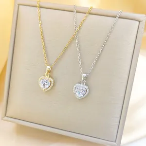 Nahaufnahme von herzförmigen Zirkonia-Anhängern in Gold und Silber auf Seidenstoff