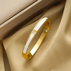Elegant gold titanium steel oval bangle with white shell inlay and three mini crystals