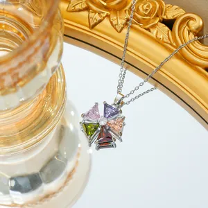 Macro-opname van een kleurrijke zirkoon bloemhanger aan een fijne roestvrijstalen ketting