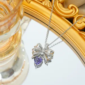 Bowknot heart necklace with purple zircon and silver chain on a mirror background