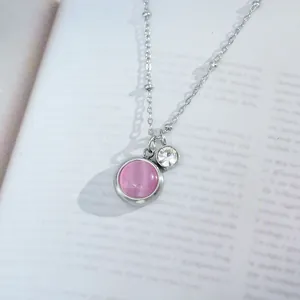 Macro view of silver titanium steel necklace with pink cat eye stone and sparkling zircon