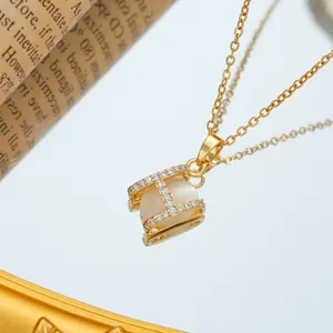 Golden H-letter necklace with opal gemstone and sparkling rhinestones on mirror