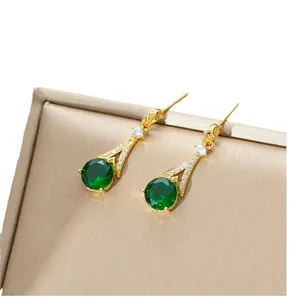 Luxurious gold drop earrings featuring green stones and pavé set sparkling zircons