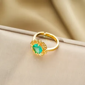 Détail macro d'une bague ajustable dorée vintage avec une grande pierre précieuse verte