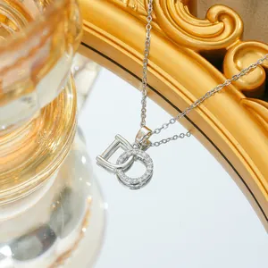 Macro shot of interlocking silver-tone D-shaped letters with cubic zirconia inlay