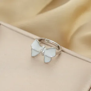 Elegant silver bow ring with pearl finish and cubic zirconia inlay on champagne silk