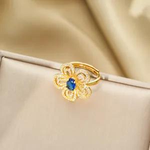 Dettaglio macro dell'anello a fiore dorato con zaffiro blu e petali di zirconi