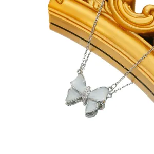 Silver bow butterfly necklace with white shell inlay and zircon stones on a gold frame