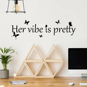 Vue détaillée du sticker mural noir 'Her vibe is pretty' avec papillons dans un bureau