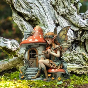 Detail of fairy girl with flute and mushroom house miniature in moss garden decor