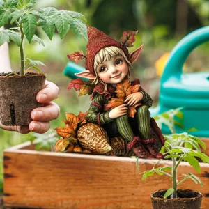 Detail of garden gnome elf ornament sitting on autumn leaves for outdoor decor