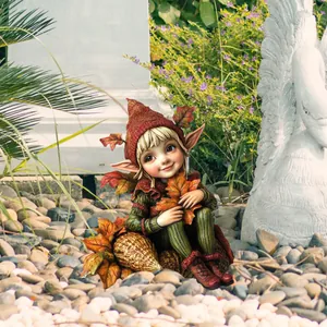 Garden gnome figurine wearing striped clothes and red hat sitting on stone among plants