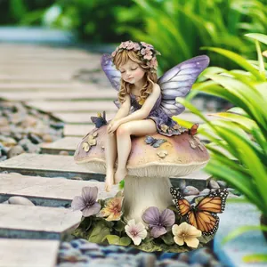 Whimsical garden fairy statue sitting on mushroom with colorful butterflies and flowers