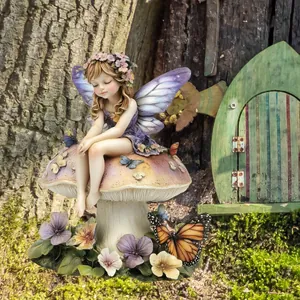 Detail of flower fairy garden stake sitting on mushroom with purple wings and butterflies