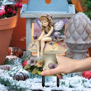Garden stake showing a fairy on a colorful mushroom held by hand for size scale