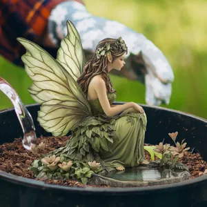 Detailed close-up of a resin forest fairy ornament with wings in a miniature garden