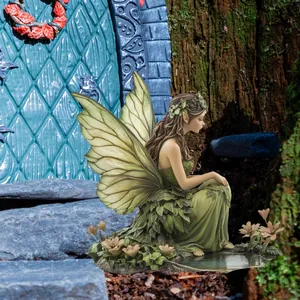 Detailed garden fairy ornament with leafy green dress and translucent wings in forest setting