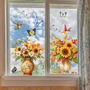 Détail de stickers de tournesols et colibris sur verre clair sous un ciel lumineux