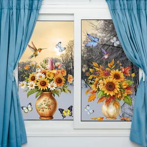 Détail de stickers tournesol et colibri sur vitre avec vue sur paysage enneigé