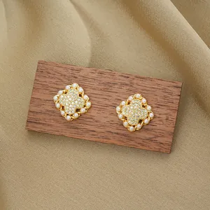 Elegante goldene Kleeblatt-Ohrringe mit Zirkonia-Mitte und Perlenrand auf Seide