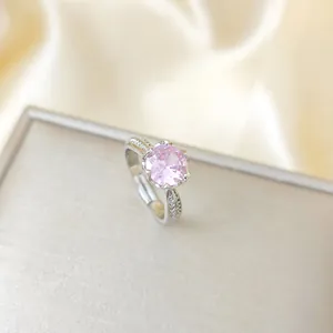 Macro di un anello d'argento con un grande zircone rosa e piccoli cristalli laterali