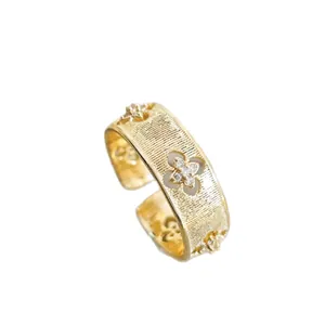 Vintage gold adjustable ring with clover cutouts, brushed texture, and zircon inlay