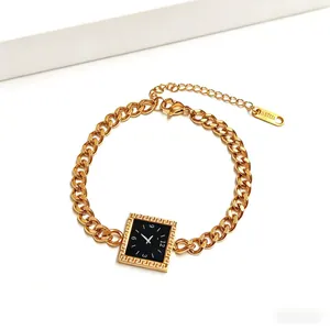Detail of gold stainless steel bracelet with Greek key pattern and black square dial