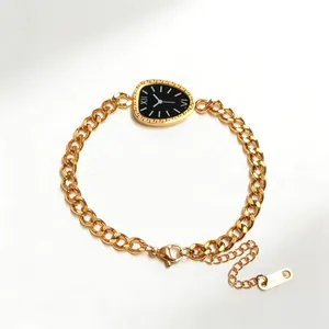 Close-up of gold chain bracelet with Greek key pattern dial charm and lobster clasp