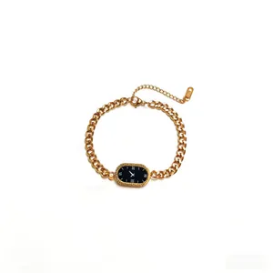 Detail of golden stainless steel chain bracelet with Greek key pattern and Roman dial charm