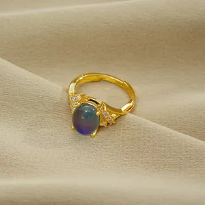 Goldener Kreuzring mit temperaturabhängigem Farbwechselstein und Zirkonia-Akzenten