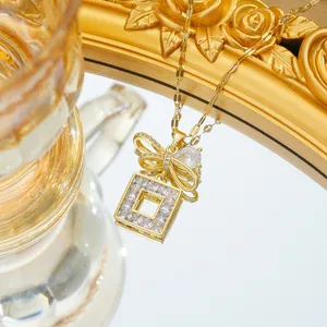 Détail du collier doré avec pendentif nœud géométrique et zircons scintillants