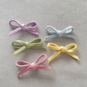 Close-up of five handmade colorful woven fabric bow accessories for DIY hair clips