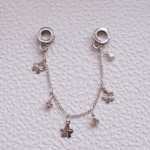 Detail der silbernen Sicherheitskette mit mattierten Blumen und Zirkon-Quastenanhängern