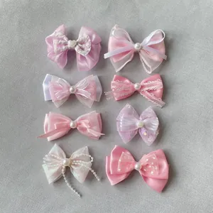 Dettaglio di fiocchi rosa fai-da-te in nastro di seta, pizzo e perle per accessori