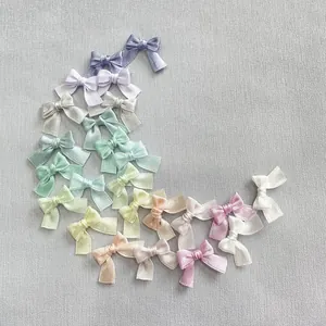 Flat lay of colorful satin bow accessories for DIY crafts and hair clips in pastel tones