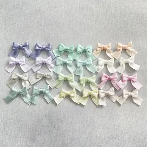 Detailed view of handmade mini satin bows in various macaron colors for DIY nail art and crafts