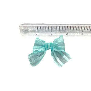 Dettaglio di un fiocco in organza a righe azzurre con righello di misurazione