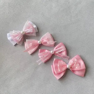 Dettaglio di fiocchi rosa fai-da-te in raso, pizzo e organza con centri di perle