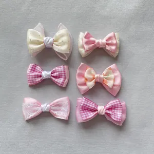 Detailed macro view of six handmade pink and beige mesh bow hair accessories for DIY crafts