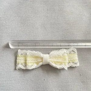 Handgefertigte Schleife aus weißer Spitze und gelbem Band mit Lineal für DIY-Zubehör