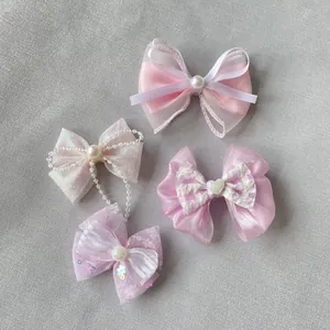 Dettaglio ravvicinato di fiocchi rosa fatti a mano con perle e paillettes per il fai da te