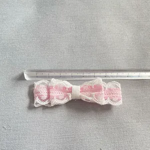 Nahaufnahme einer 8cm weißen und rosa Spitzenschleife für DIY-Puppenkleidung und Basteln