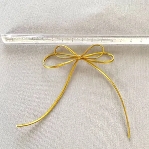 Detail einer großen goldenen PU-Lederschleife mit Lineal zur Anzeige der 11,5 cm Breite