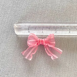 Dettaglio di un mini fiocco in organza rosa da 3cm per accessori capelli fai-da-te