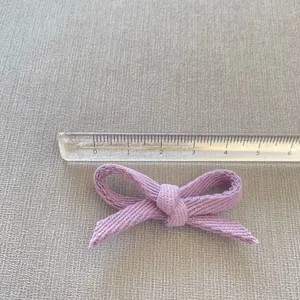 Detailed view of handmade light purple fabric bow showing 5.5cm width measurement