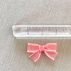 Mini pink mesh bow accessory for DIY crafts and hair clips with measurement scale