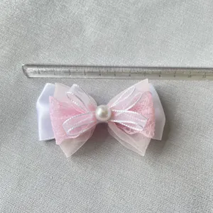 Fiocco rosa fai-da-te in pizzo e mesh con perla su sfondo grigio, larghezza di 9 cm