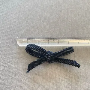 Detail view of a 5.5cm blue and white woven denim style bow for DIY hair accessories