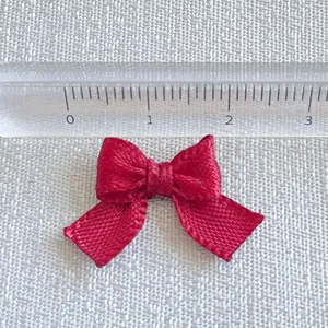 Red mini ribbon bow with a scale ruler showing size for DIY crafts and pet accessories